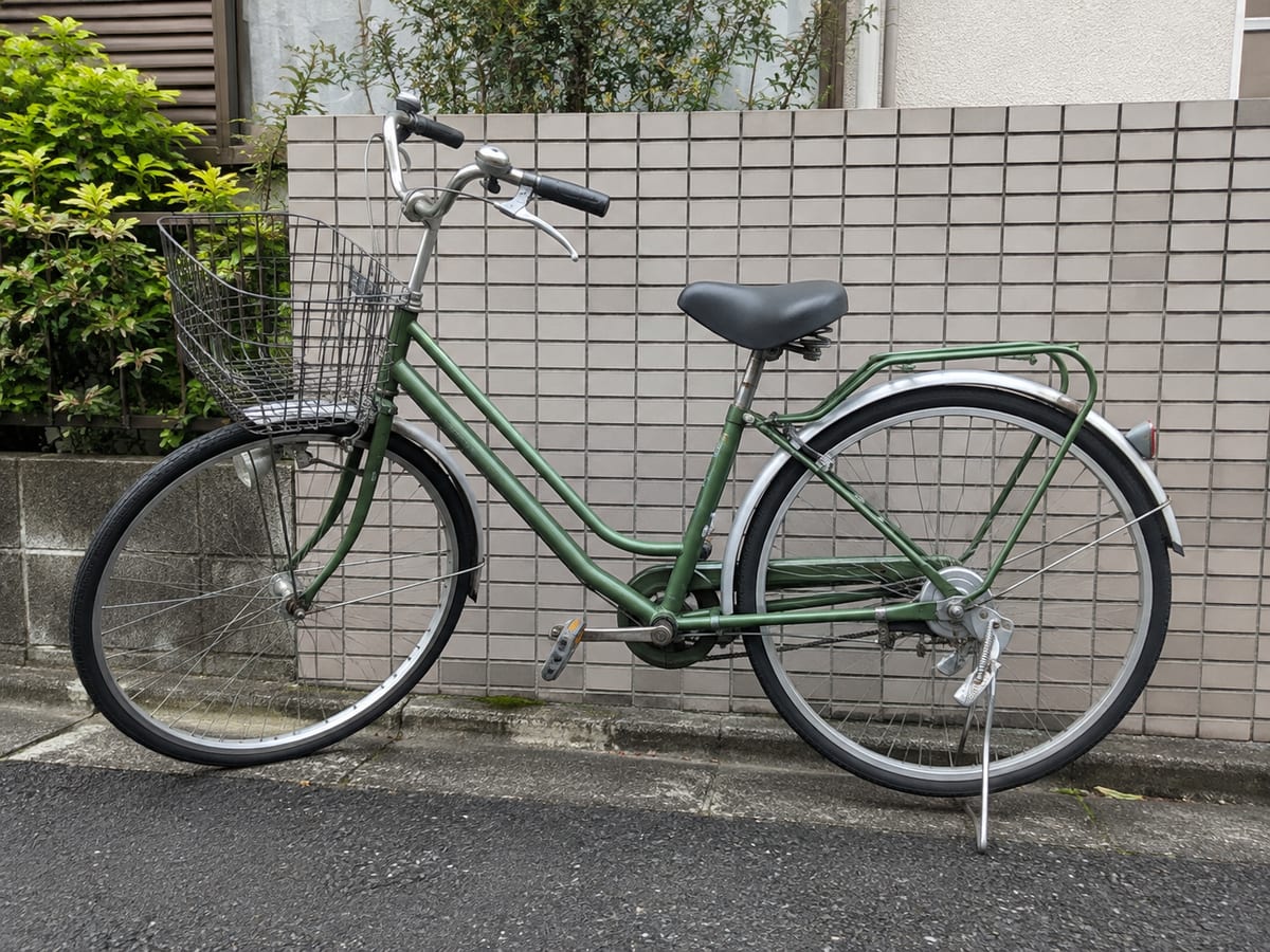 住宅街の壁際に停められた緑色の自転車